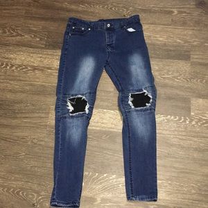 Dark blue jeans with black in the ripped holes